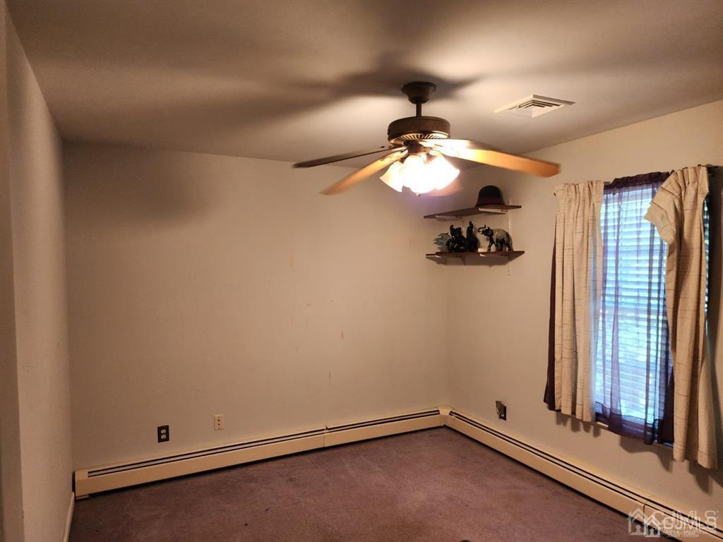 184 Raritan Street Keyport, NJ 07735 - Photo 12 of 24 an empty room with a chandelier fan and windows