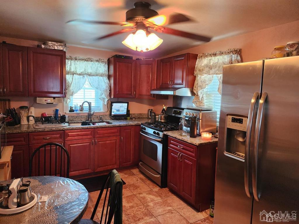 184 Raritan Street Keyport, NJ 07735 - Photo 8 of 24 a kitchen with stainless steel appliances granite countertop a sink a stove a refrigerator cabinets and chairs