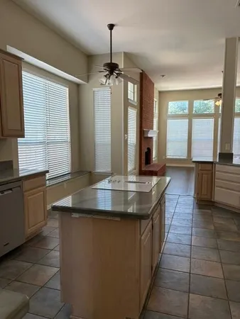 a kitchen with kitchen island granite countertop a sink a counter top space and stainless steel appliances