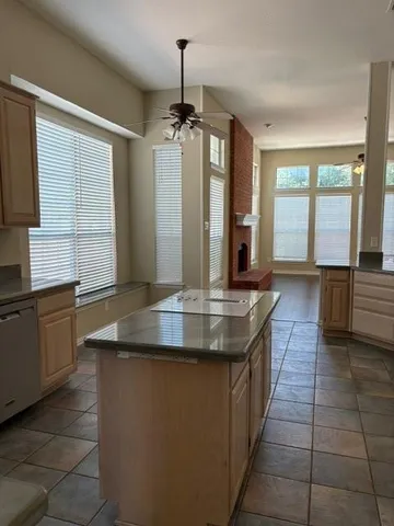 a kitchen with kitchen island granite countertop a sink a counter top space and stainless steel appliances