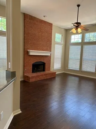 a view of wooden floor fire place and windows in a room