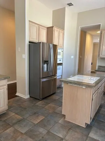 a kitchen with stainless steel appliances granite countertop a refrigerator and a stove