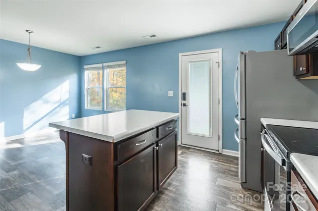 a kitchen with granite countertop a stove and a refrigerator