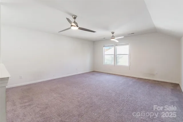 an empty room with a window and a ceiling fan