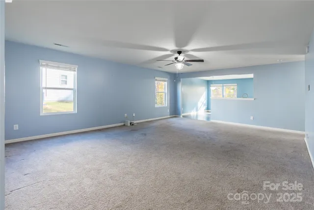 a view of a livingroom with a ceiling fan and window
