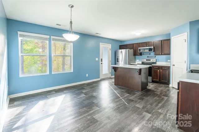 a kitchen with stainless steel appliances granite countertop a stove top oven a sink dishwasher and a refrigerator