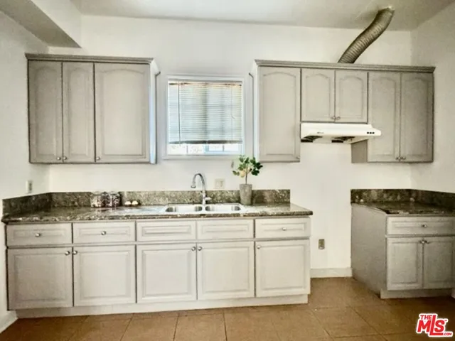 a kitchen with stainless steel appliances granite countertop a sink and cabinets