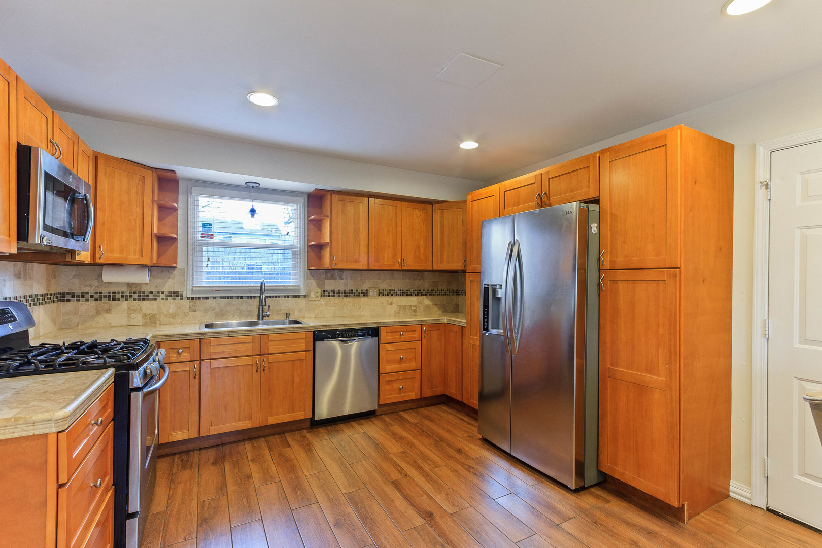 524 Spruce Road Bolingbrook, IL 60440 - Photo 12 of 33 a kitchen with stainless steel appliances granite countertop a refrigerator a sink dishwasher and wooden cabinets with wooden floor