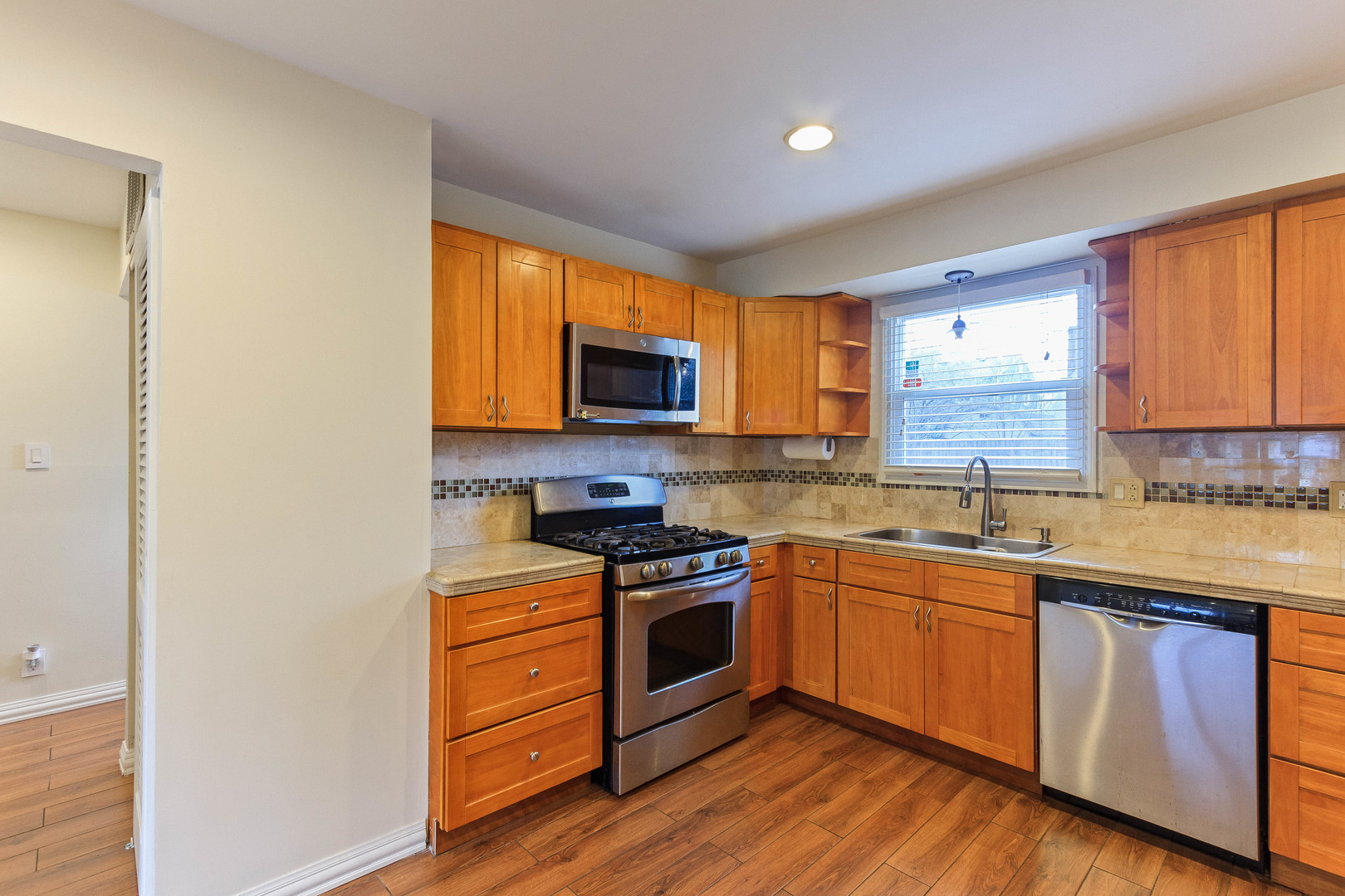 524 Spruce Road Bolingbrook, IL 60440 - Photo 13 of 33 a kitchen with stainless steel appliances granite countertop wooden cabinets a sink a stove a microwave and floors