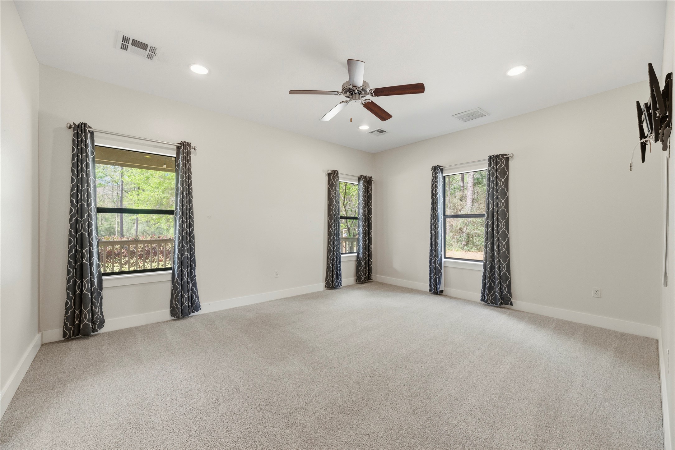 12062 Ike White Road Conroe, TX 77303 - Photo 19 of 37 Primary retreat with plush carpet, ceiling fan and en-suite bathroom.