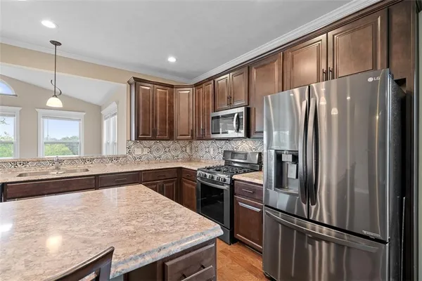 a kitchen with granite countertop a refrigerator stove and sink