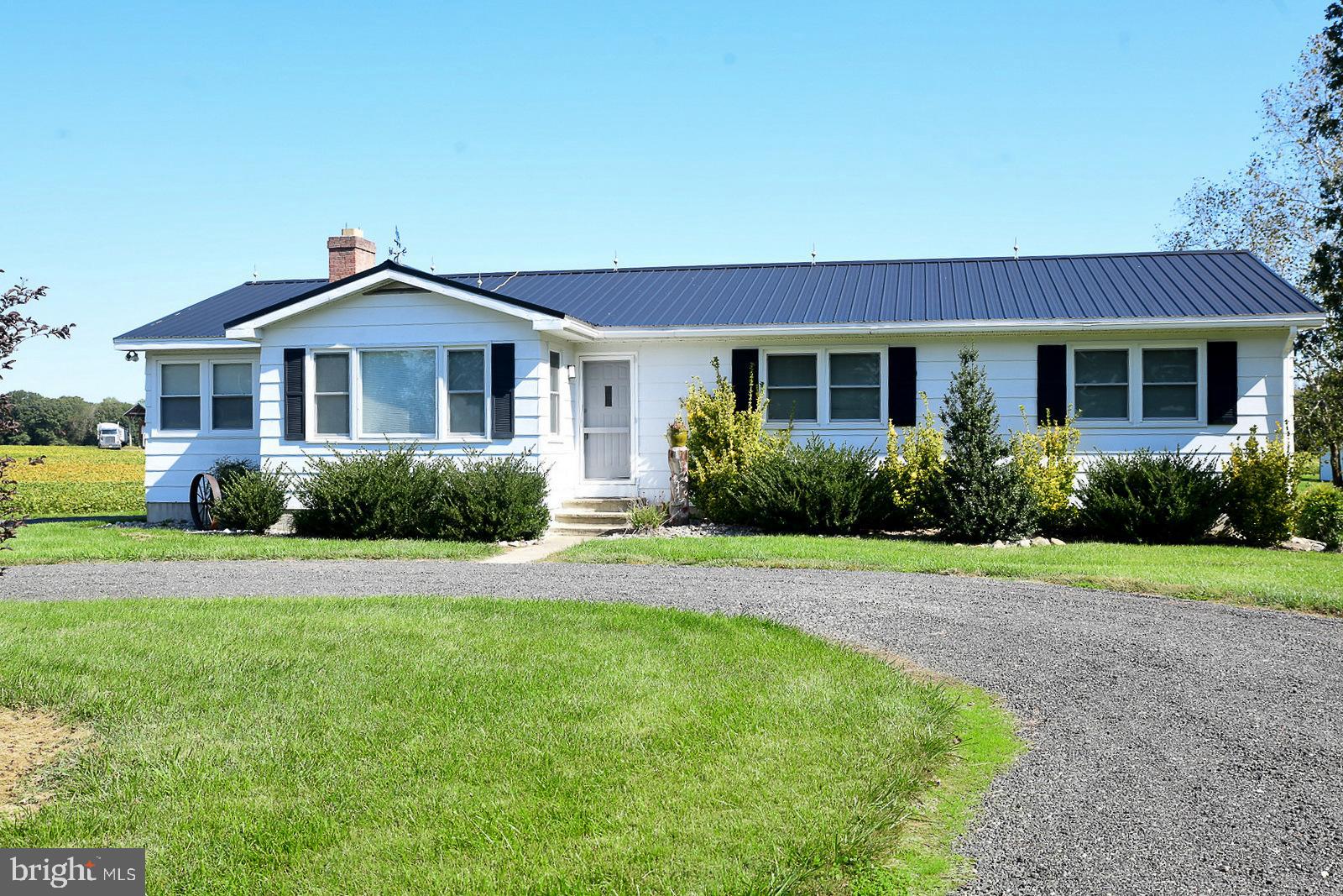 a front view of a house with a yard and trees