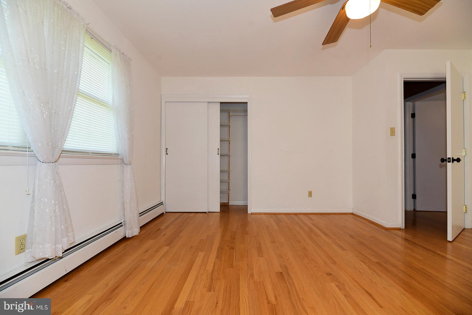 40480 Parsons Mill Road Leonardtown, MD 20650 - Photo 20 of 48 an empty room with wooden floor fan and windows