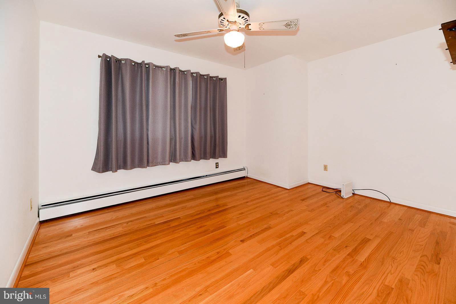 40480 Parsons Mill Road Leonardtown, MD 20650 - Photo 26 of 48 an empty room with wooden floor fan and windows