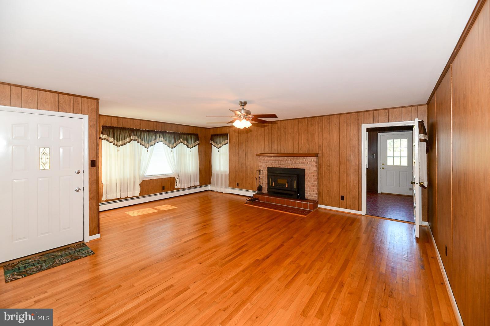 40480 Parsons Mill Road Leonardtown, MD 20650 - Photo 3 of 48 an empty room with wooden floor fireplace and windows