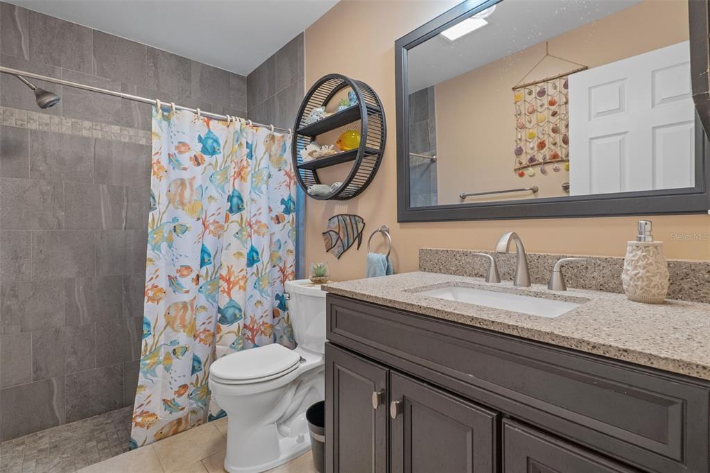 2643 Royal Ridge Drive Spring Hill, FL 34606 - Photo 26 of 84 a bathroom with a granite countertop toilet a sink and a mirror