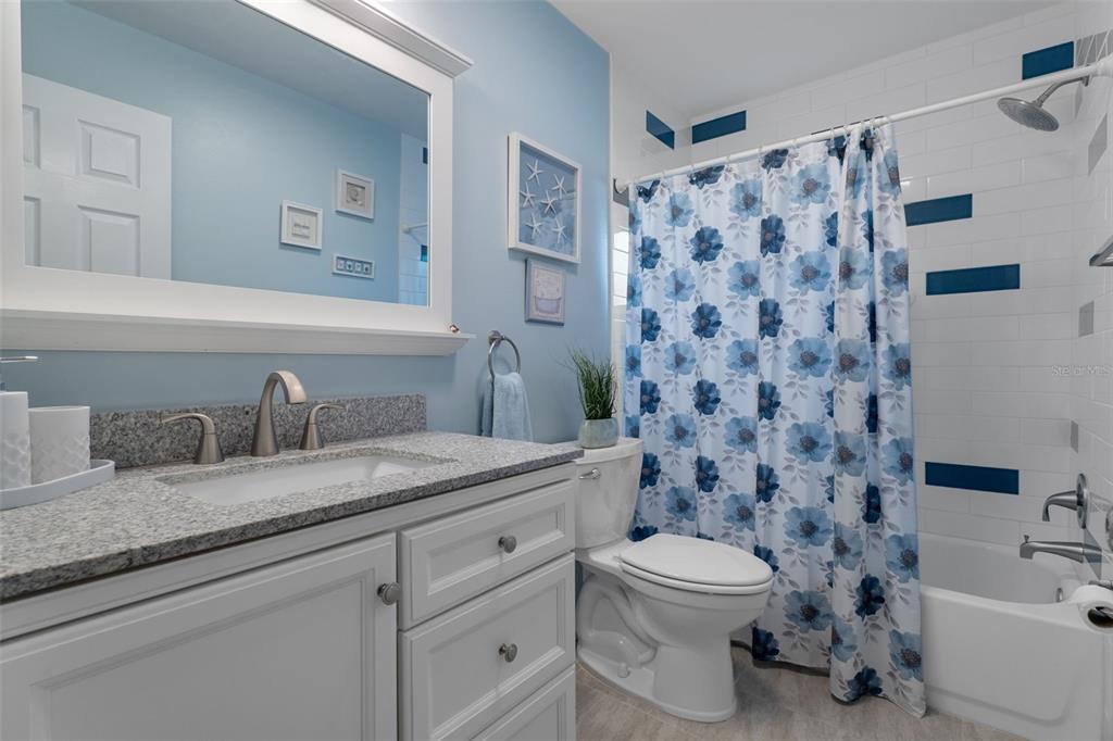 2643 Royal Ridge Drive Spring Hill, FL 34606 - Photo 27 of 84 a bathroom with a granite countertop sink a toilet and a mirror