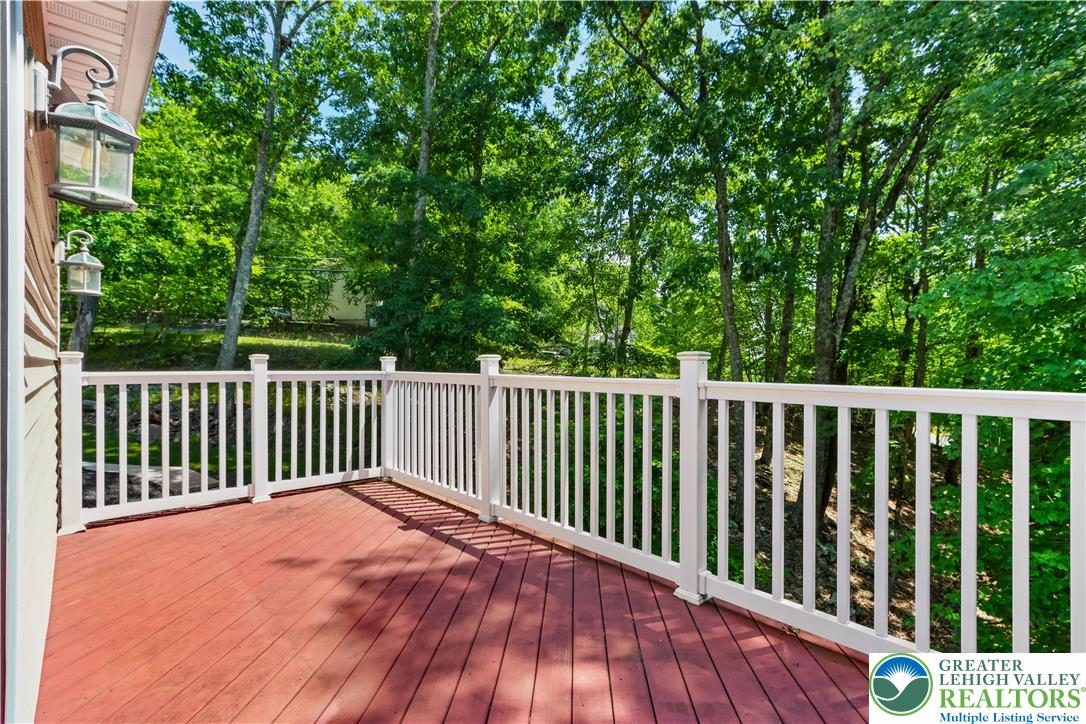 1007 Hampstead Road Bushkill, PA 18324 - Photo 10 of 72 A spacious wooden deck provides a serene outdoor living area, overlooking a lush, verdant treeline.