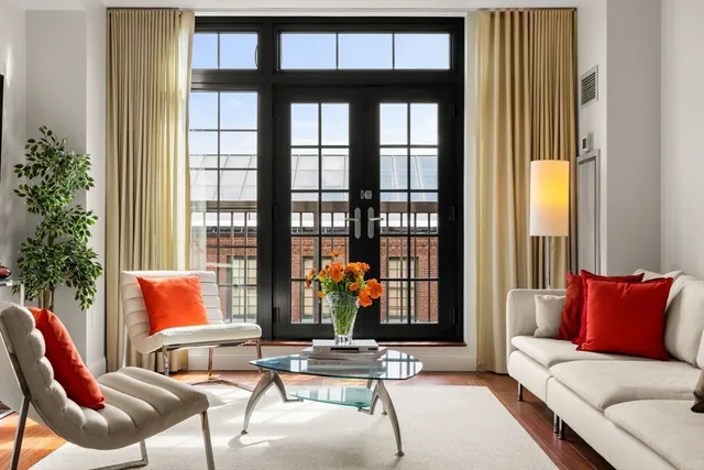 a living room with furniture and floor to ceiling windows