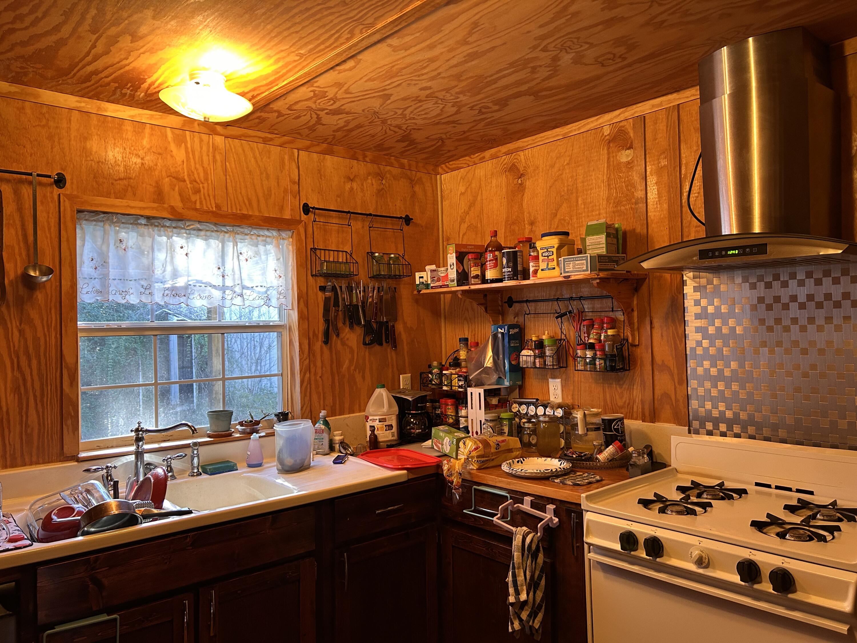 6853 Preston Posey Road Baker, FL 32531 - Photo 4 of 12 a kitchen with a sink stove and cabinets