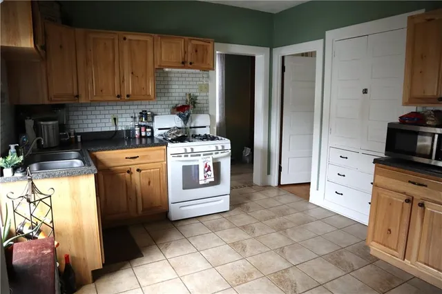 a kitchen with stainless steel appliances granite countertop a stove a refrigerator and a cabinets
