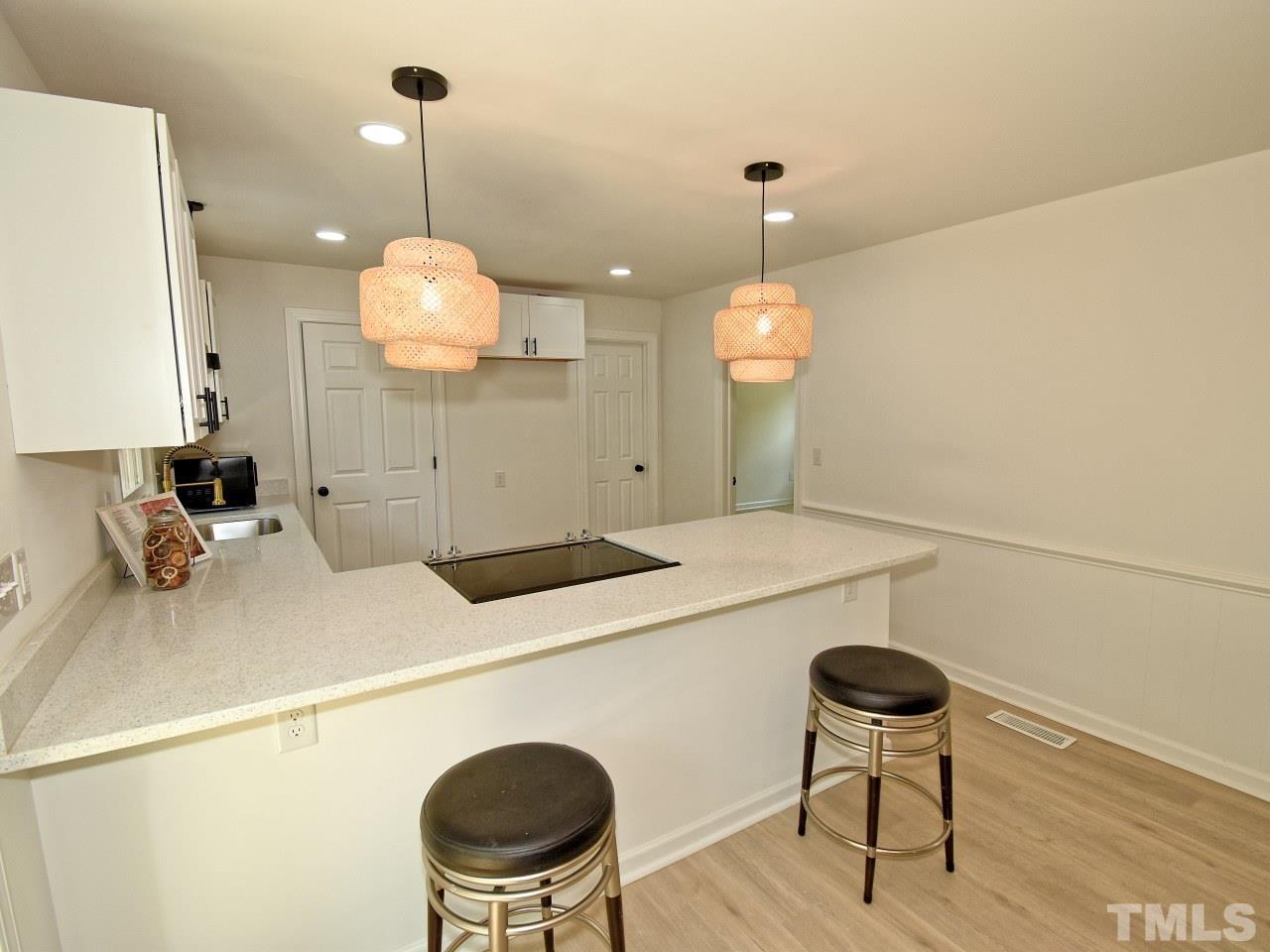 6530 Jean Drive Raleigh, NC 27612 - Photo 11 of 32 a kitchen with a refrigerator a sink and a chandelier