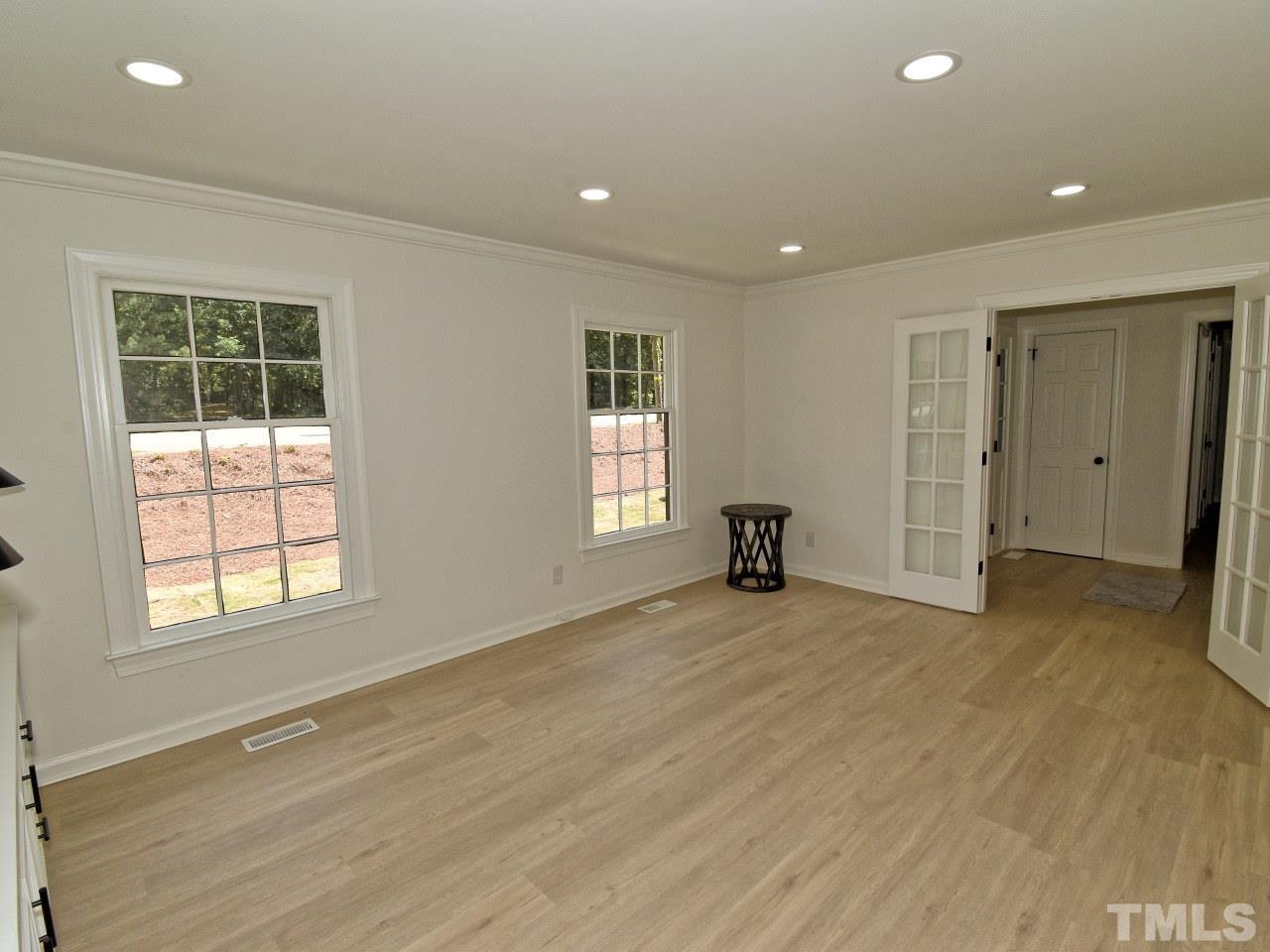 6530 Jean Drive Raleigh, NC 27612 - Photo 13 of 32 an empty room with wooden floor and windows