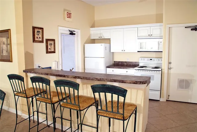 a kitchen that has a table chairs and a refrigerator
