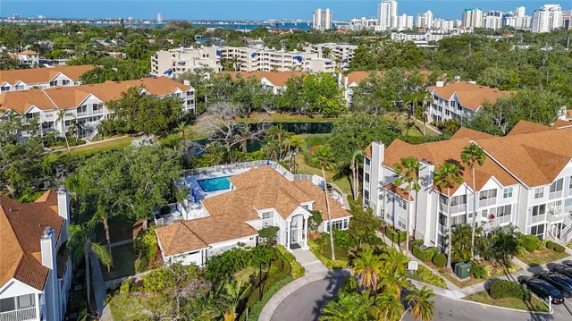 an aerial view of residential houses with outdoor space and trees