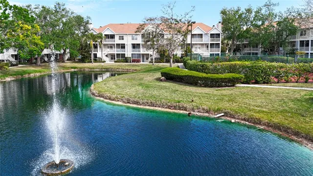 a view of a house with a yard and a fountain