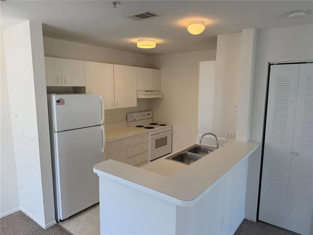 a white refrigerator freezer sitting inside of a kitchen