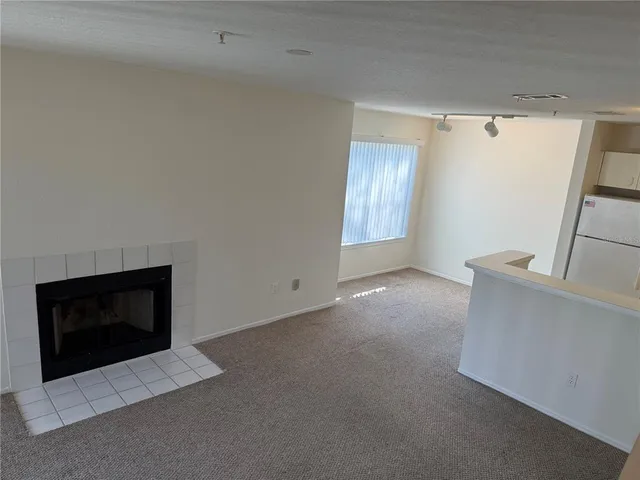 a view of an empty room with closet and a fireplace