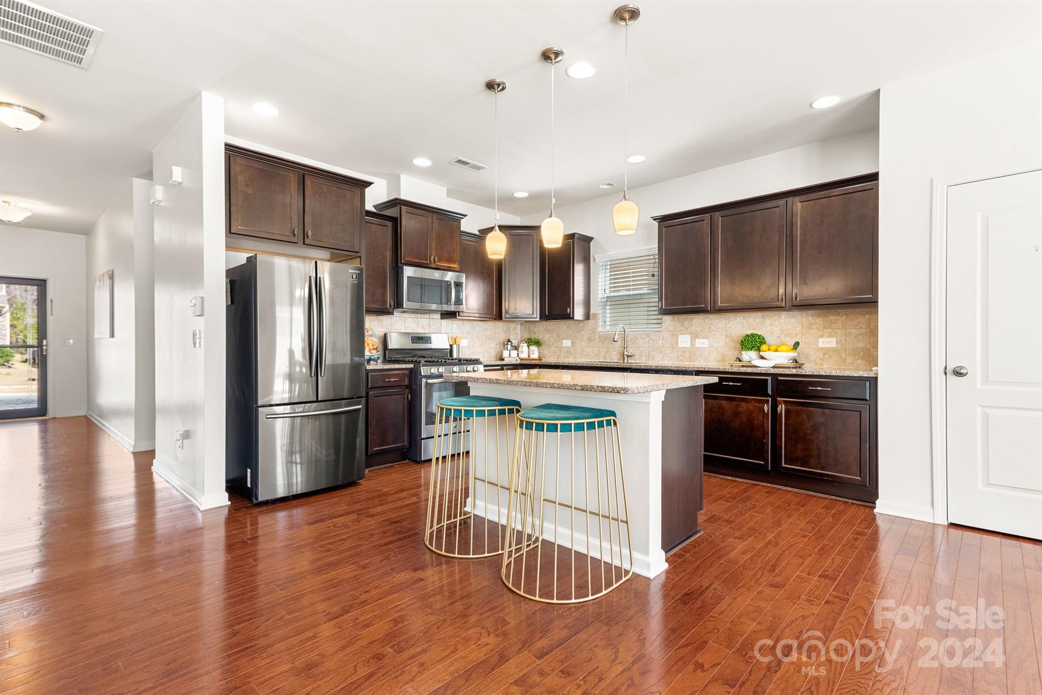 1555 Spring Blossom Trail Fort Mill, SC 29708 - Photo 10 of 47 a kitchen with kitchen island granite countertop stainless steel appliances cabinets a sink and a counter top space