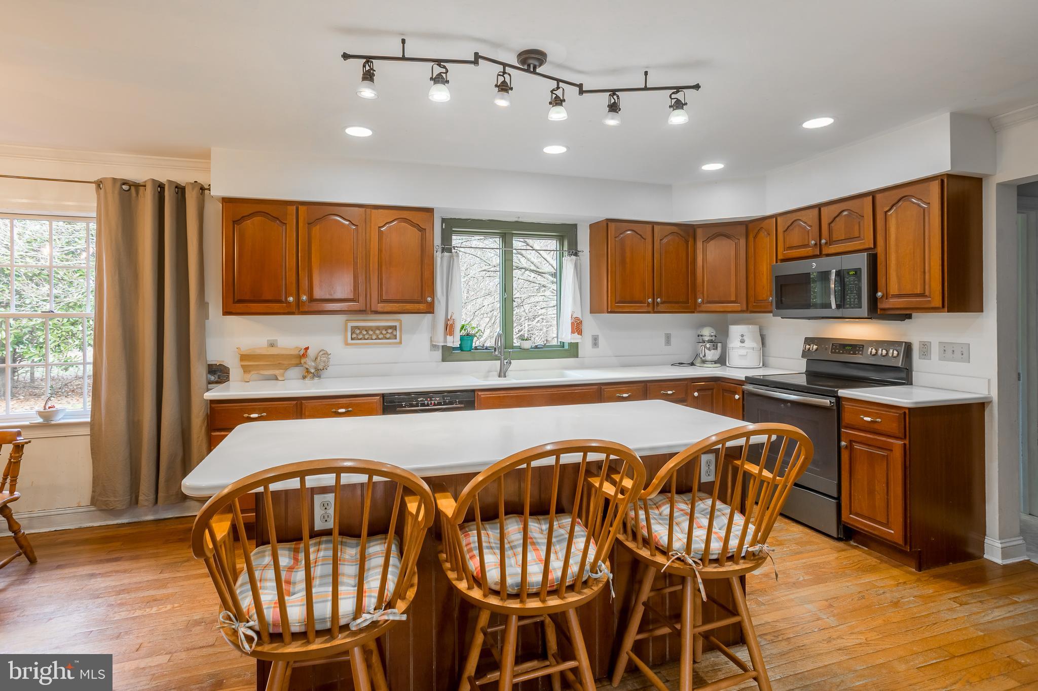 7904 Clark Road Denton, MD 21629 - Photo 15 of 71 a kitchen with stainless steel appliances granite countertop a stove top oven a sink a refrigerator with a dining table and chairs with wooden floor