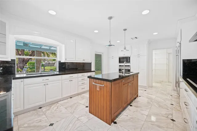 a kitchen with stainless steel appliances granite countertop a stove a sink and a refrigerator