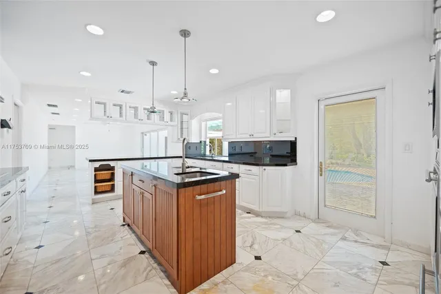 a kitchen with stainless steel appliances granite countertop a stove a sink and a refrigerator