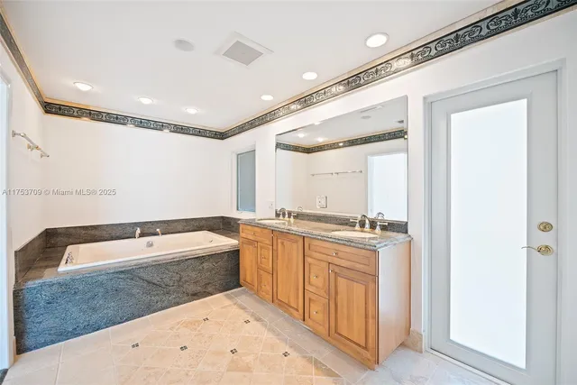 a bathroom with a tub sink and mirror