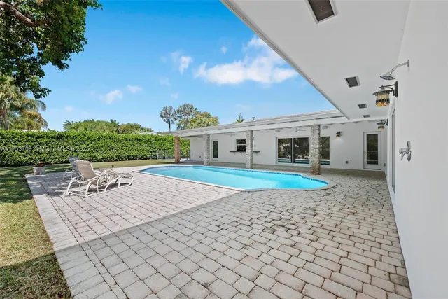 an aerial view of a house with a yard swimming pool and outdoor seating