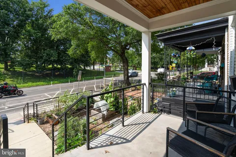 a view of a balcony with floor to ceiling windows wooden floor and fence