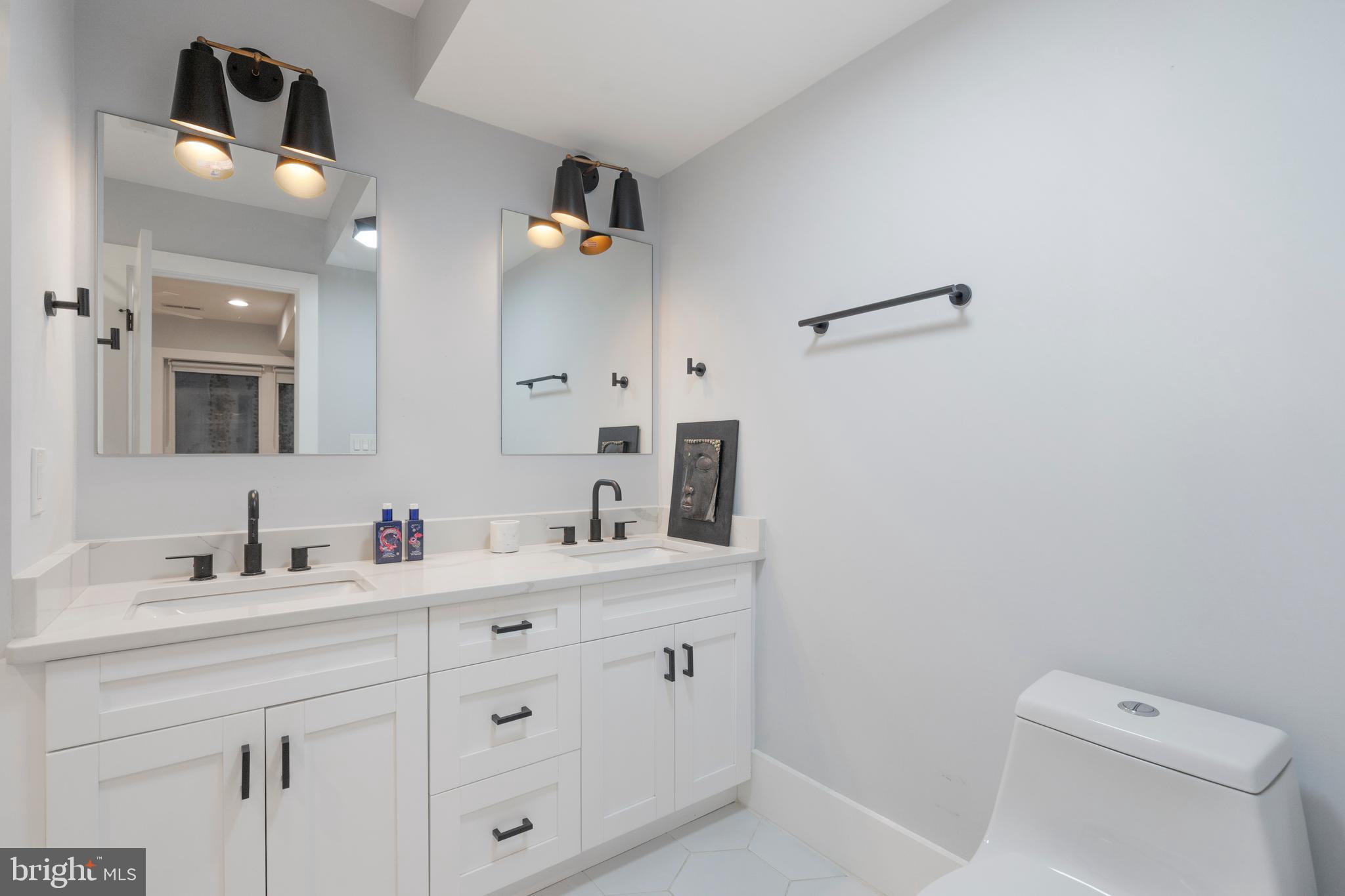 1427 West Virginia Avenue Northeast, Unit 1 Washington, DC 20002 - Photo 33 of 46 a bathroom with a double vanity sink toilet and mirror
