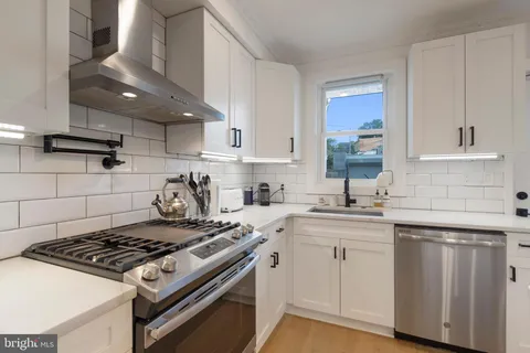 a kitchen with sink stove and cabinets