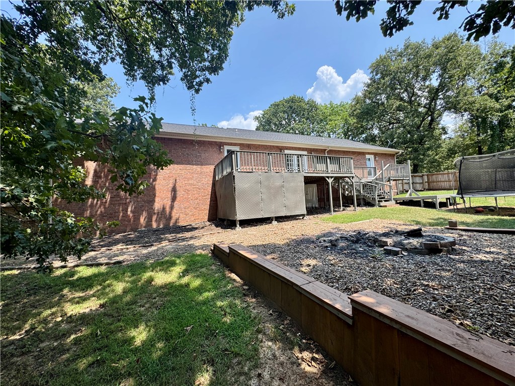 1197 Ridgeview Lane Russellville, AR 72802 - Photo 40 of 44 Spacious backyard retreat featuring mature shade trees, gravel hardscaping, and a brick utility building with covered storage structure