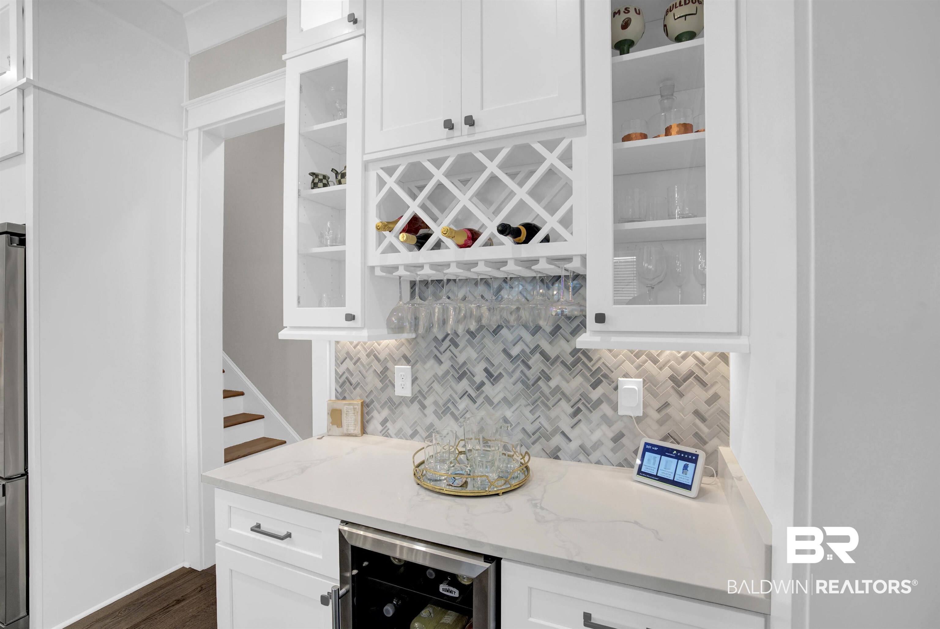 10940 Atrium Avenue Fairhope, AL 36532 - Photo 12 of 43 Bar with backsplash, dark wood-type flooring, light stone countertops, white cabinetry, and beverage cooler