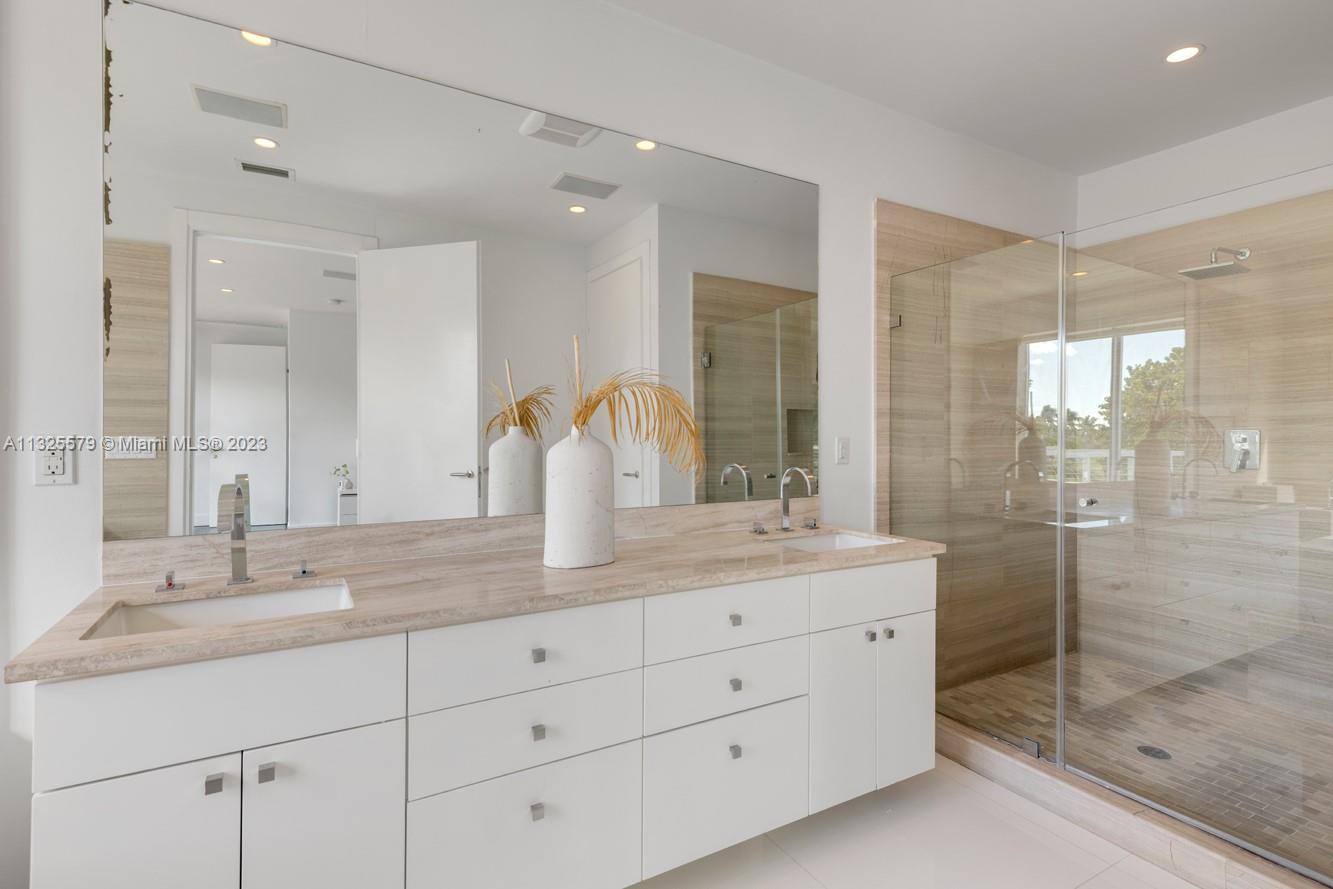 6050 La Gorce Drive Miami Beach, FL 33140 - Photo 22 of 31 a bathroom with a shower sink and mirror