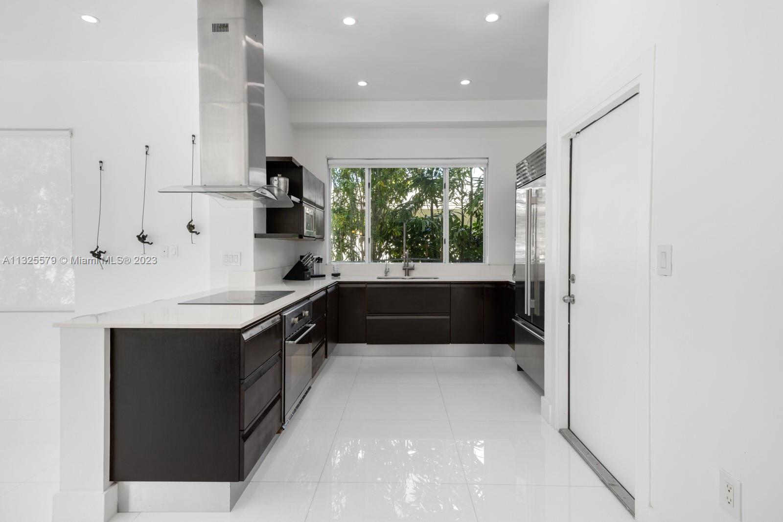 6050 La Gorce Drive Miami Beach, FL 33140 - Photo 6 of 31 a large white kitchen with a sink and large window