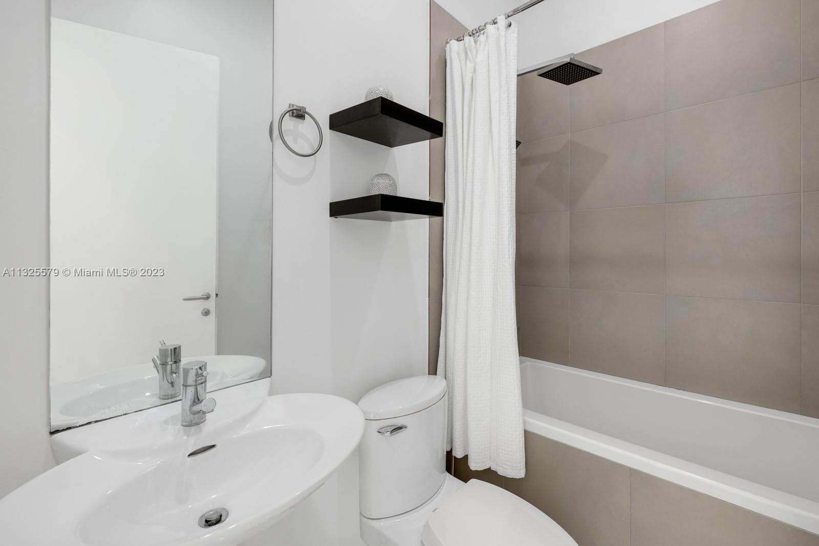 6050 La Gorce Drive Miami Beach, FL 33140 - Photo 9 of 31 a bathroom with a sink toilet and shower