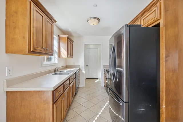 a kitchen with stainless steel appliances granite countertop a sink and a refrigerator