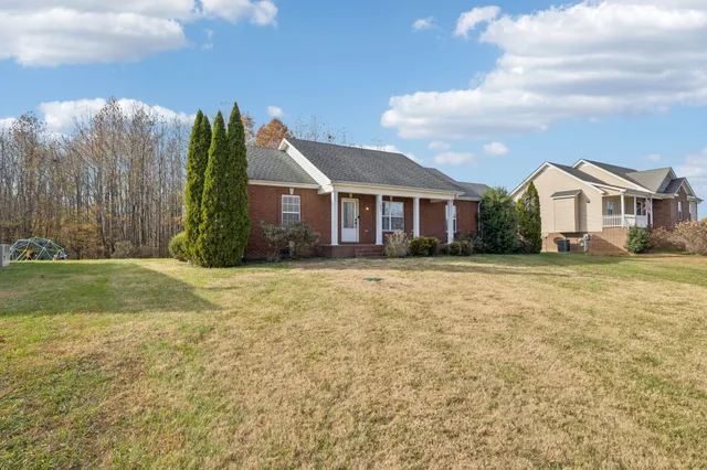 a front view of a house with a yard and trees