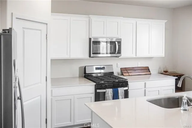 a kitchen with stainless steel appliances white cabinets and a stove