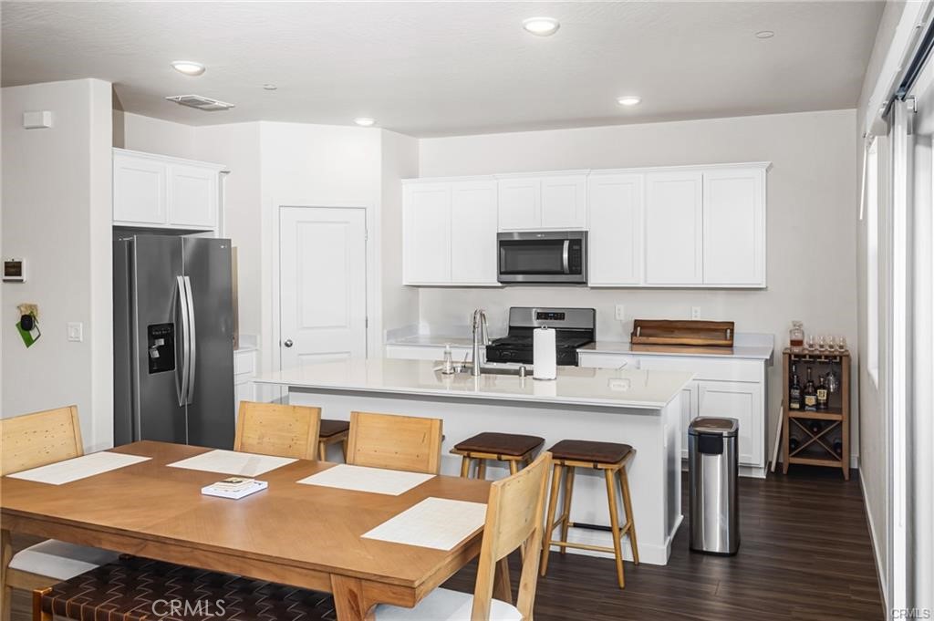 4119 Anise Court Merced, CA 95348 - Photo 3 of 17 a kitchen with stainless steel appliances granite countertop a refrigerator a stove a sink a dining table and chairs